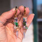 Hand holding two beaded earrings with a blurred background